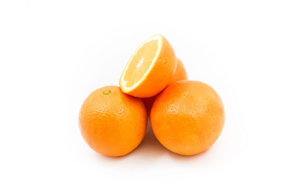 Bright and fresh oranges displayed on a white background, showcasing their vibrant color and juicy texture.