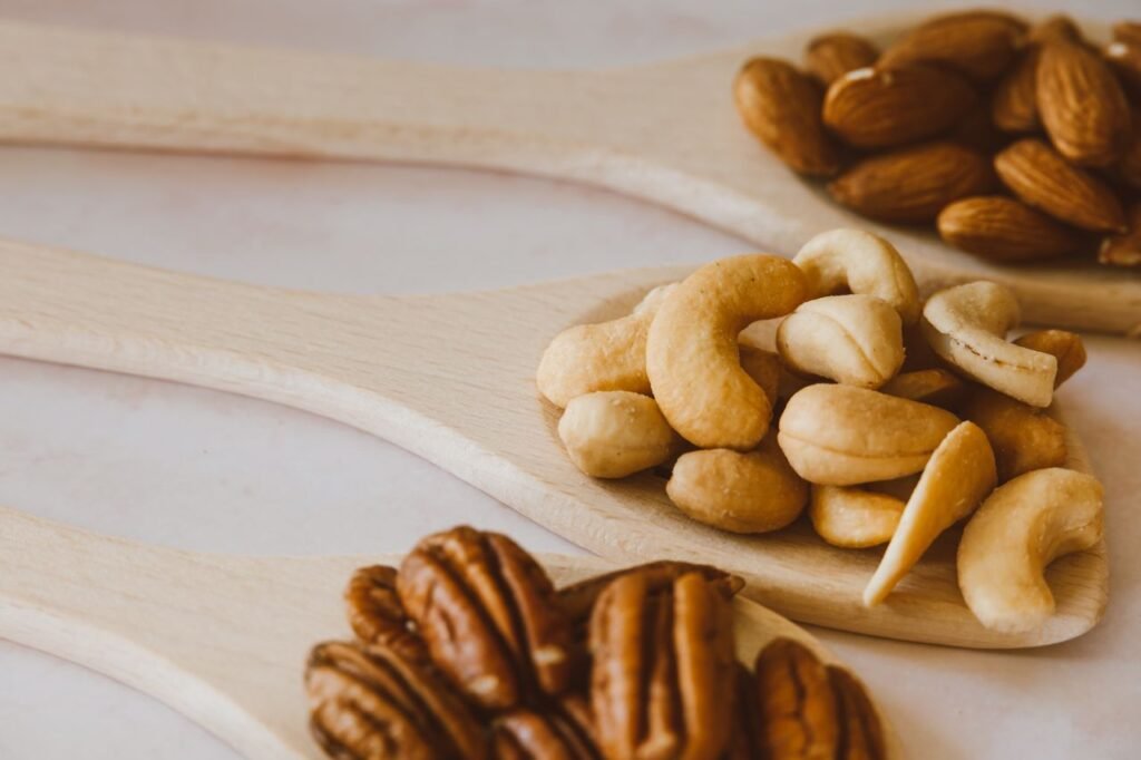 Close-up of assorted nuts in wooden spoons showcasing a healthy and organic snack option.