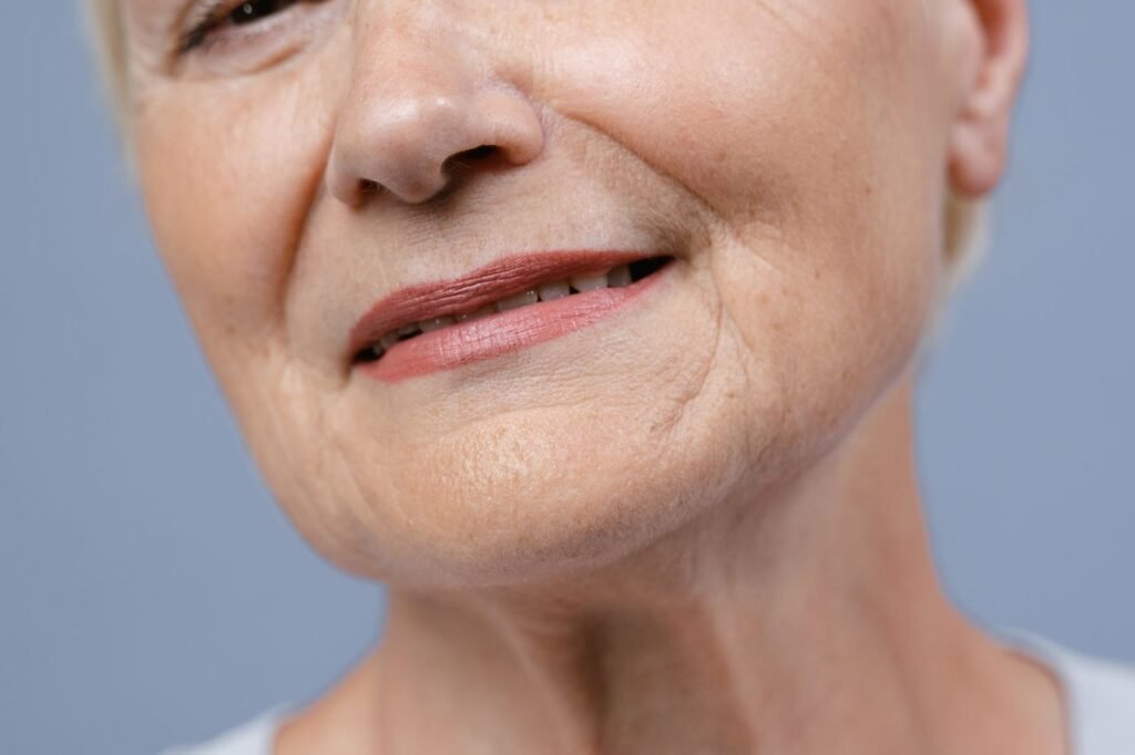 Detailed close-up of an elderly woman's lips and skin, showcasing natural wrinkles.